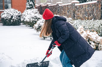 young-woman-cleans-snow-yard-snowy-weather